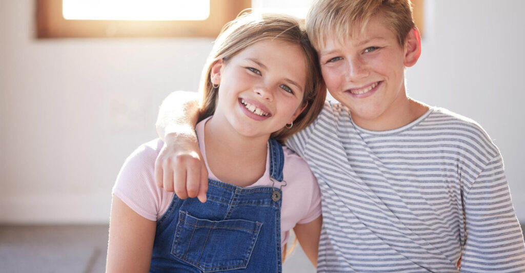 how to build strong sibling relationships: a boy and girl smiling