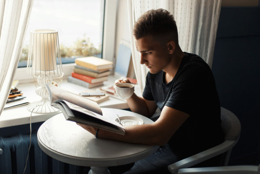 a man reading a book and drinking coffee - increase reading speed