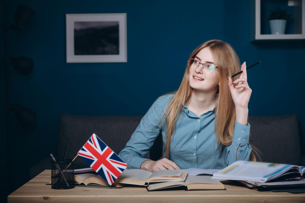 a woman sitting at a table with books and a pencil - best way to learn a language