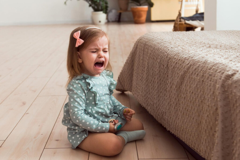 a child sitting on the floor crying: toddler tantrum strategies that actually work