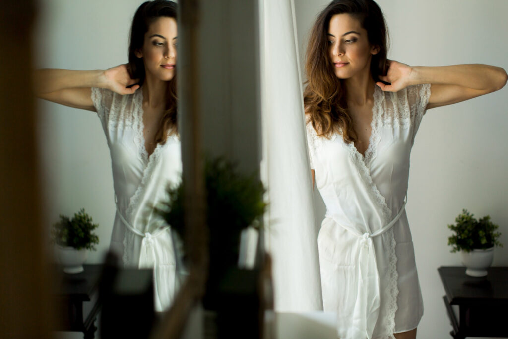 happy woman looking in the mirror - build unshakable confidence