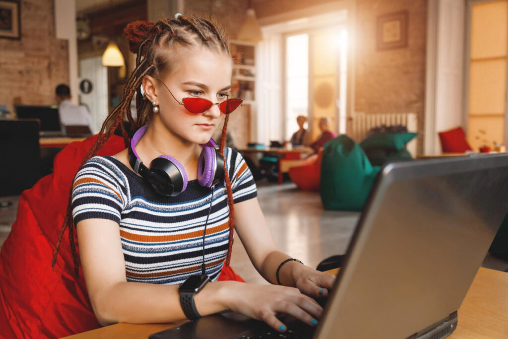 how to raise independent teenagers: a teen girl with dreadlocks using a laptop