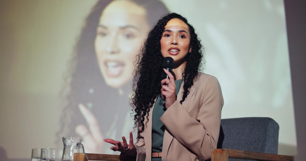 a woman speaking into a microphone
