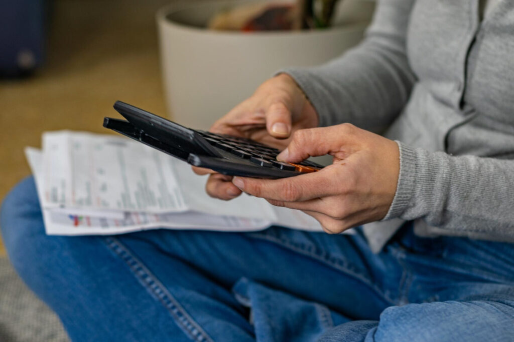 a person holding a calculator - slash bills save money