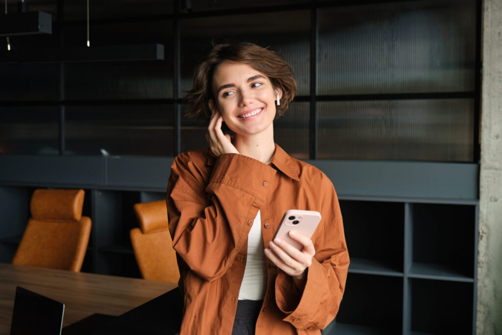 how to be confident on the phone: a woman holding a phone and smiling