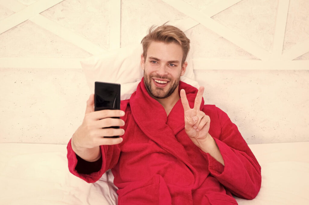 a man in a red robe taking a selfie