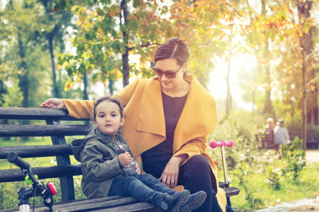 a woman and child sitting on a bench