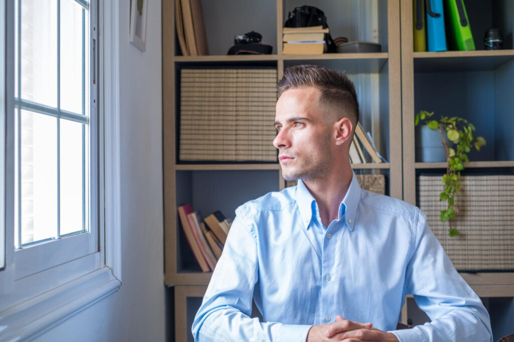 a man sitting in front of a window - separating emotions from decisions