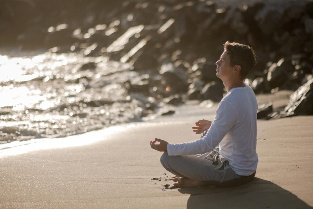 a man sitting on the beach - how to find inner peace in a chaotic world