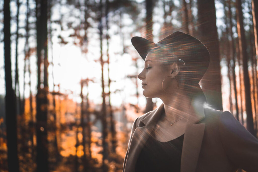 a woman in a hat in the woods