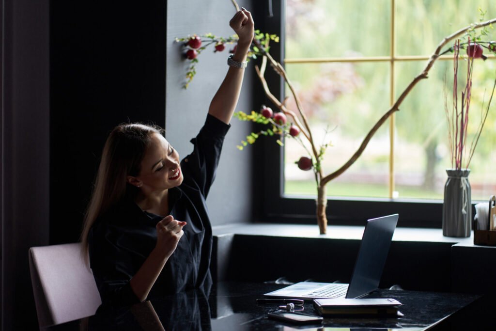 cheerful woman at her workplace - stay motivated when life gets hard
