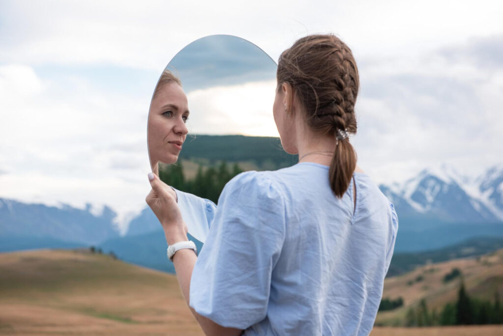 a woman looking at a mirror - create a legacy that lasts