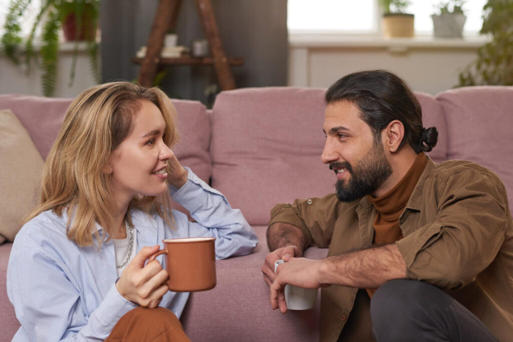Should I Stay or Leave My Relationship? a man and woman sitting on a couch and holding coffee cups