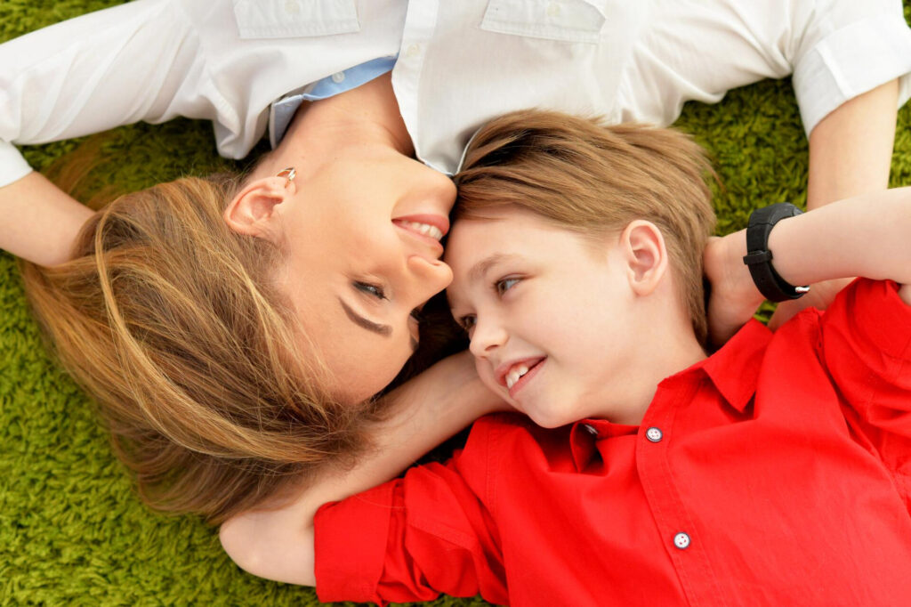 a woman and a boy lying on the ground