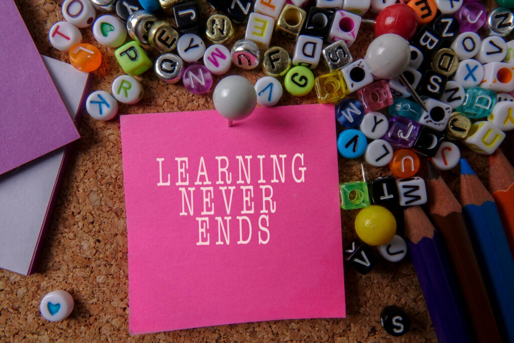 a pink note with white text on it next to a pile of beads - memory techniques for studying