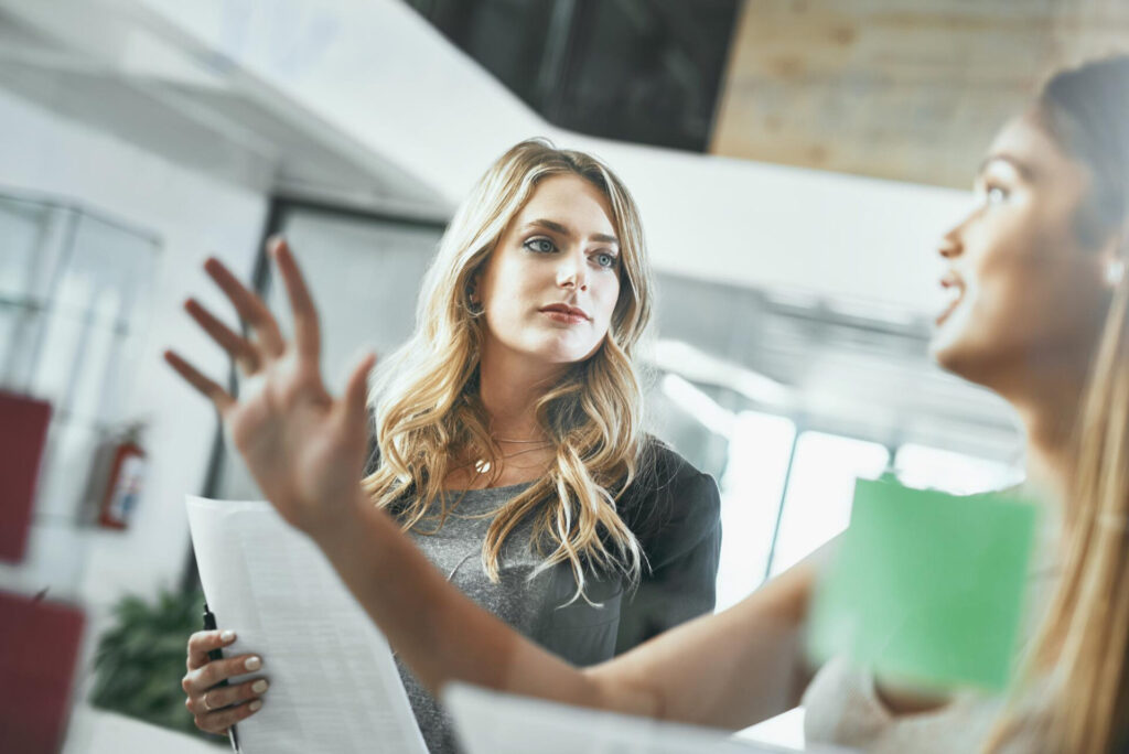 How to Give Constructive Feedback Effectively: a woman holding a paper and a man holding a pen