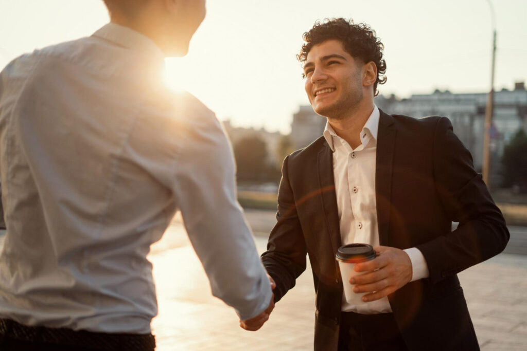 a man in suit shaking hands with another man in suit