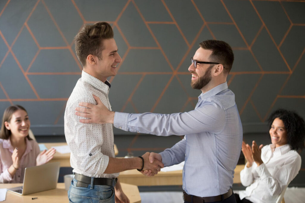 two men shaking hands in a room