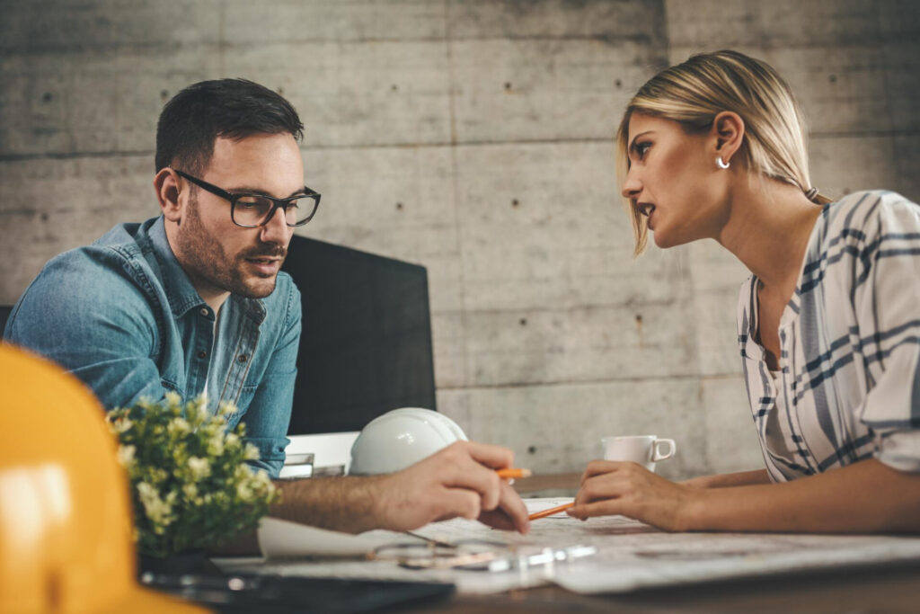 How to Give Constructive Feedback Effectively: a man and woman looking at a blueprint